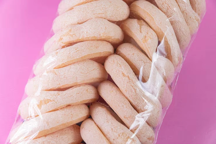Biscuits visible through a transparent bag against a pink background
