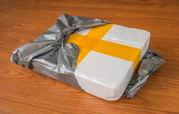 An opened grey courier mailer around a taped protective inner pack