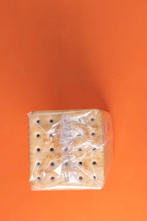 Crackers wrapped in clear film against an orange background