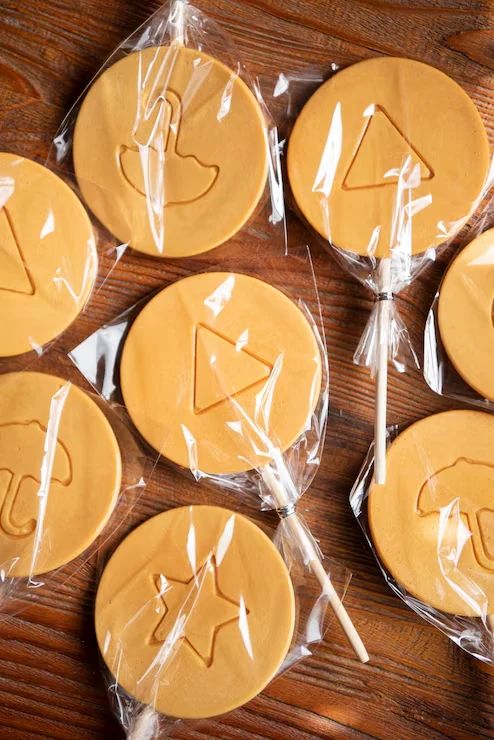 Round confectionery pieces individually wrapped in transparent film