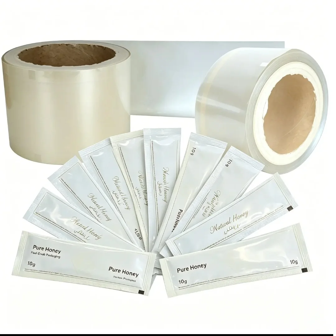 Honey sachets and transparent film rolls arranged on a white background