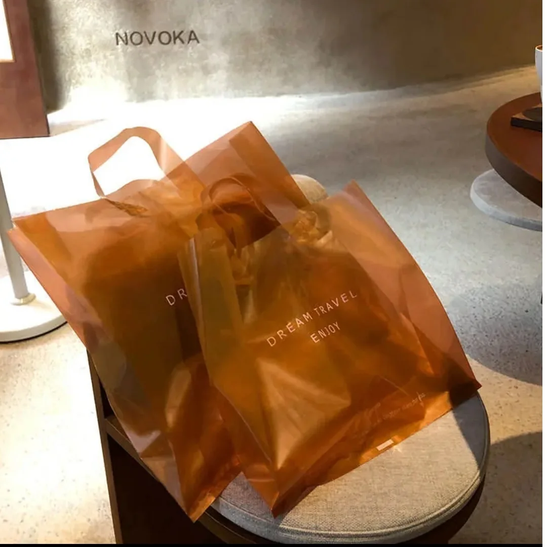 Orange translucent shopping bags displayed on a stool