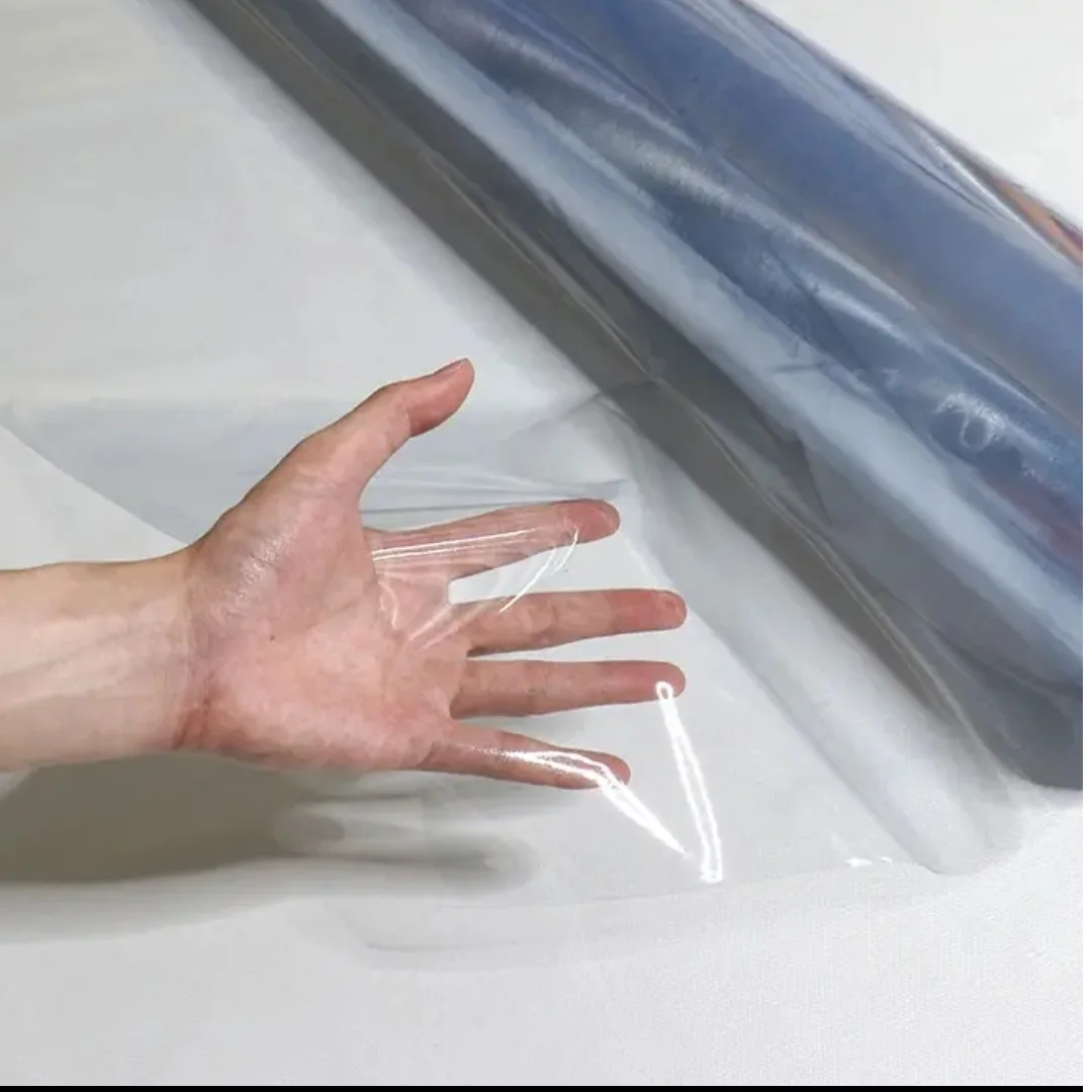 Hand visible through transparent protective film on a work surface